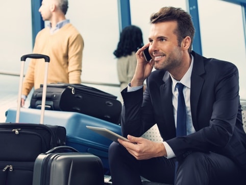Business person sitting in an airport talking on a mobile phone