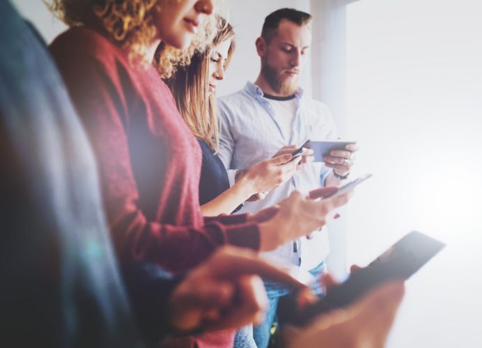 A group of people looking at smartphones