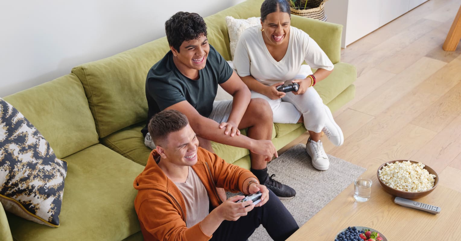 Friends sitting on a couch playing video games
