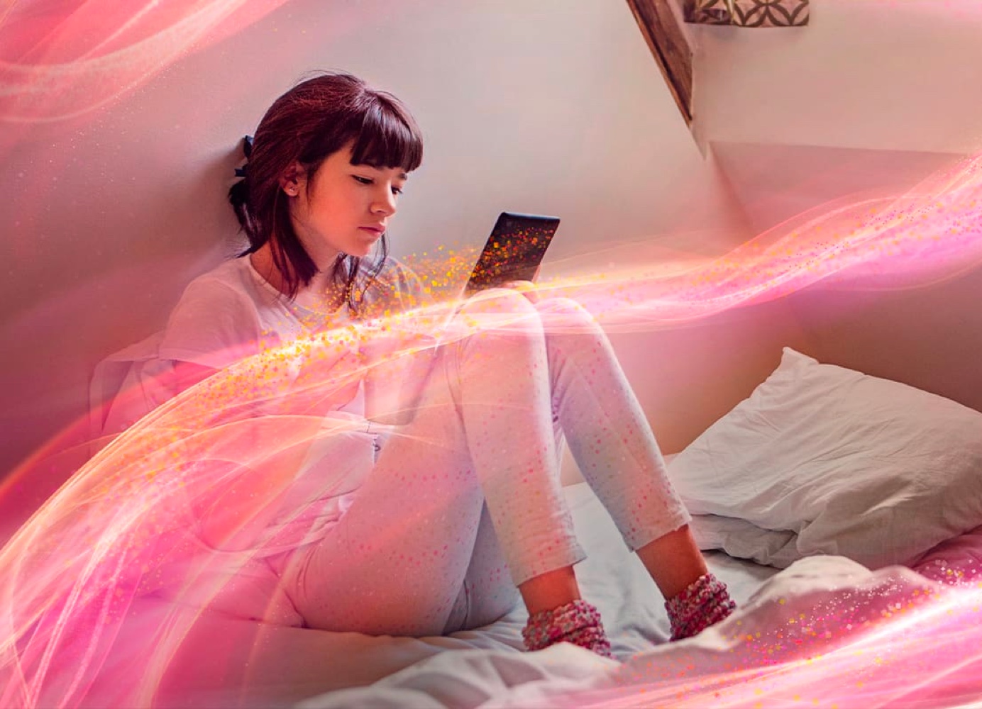 Young woman using a tablet on her bed.