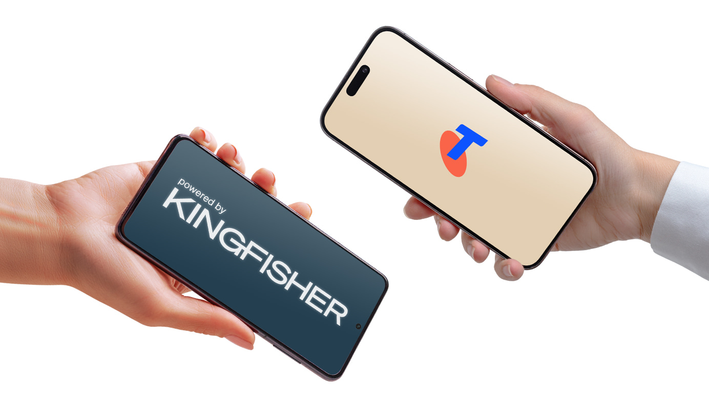 Two hands holding a mobile phone, the phone on the left side has the powered by Kingfisher image on the phone and the device on the right side has the Telstra logo on the device screen.