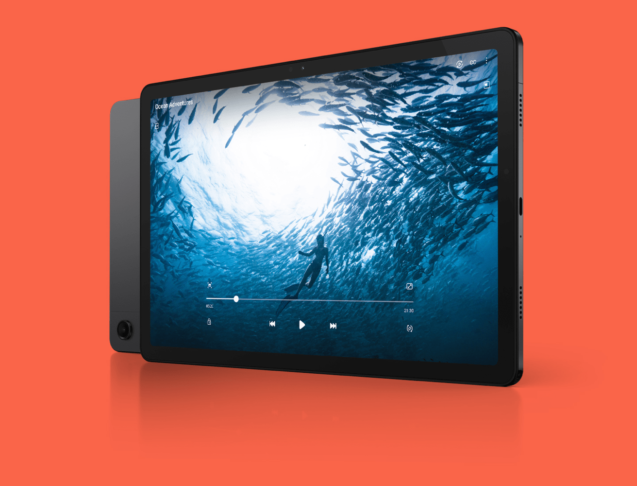 Front view and rear view of Samsung Galaxy Tab A9+ depicted at a three quarter angle facing right in colour Graphite. The front side of the device overlaps the rear side, with the rear camera slightly visible. Video featured on the display depicts a diver under water amongst a school of fish.