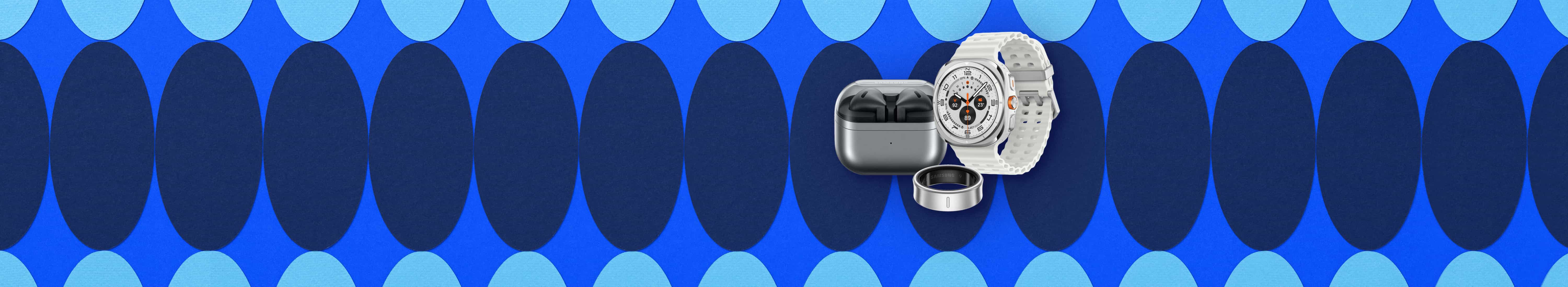 Flat lay of accessories. Black Samsung Galaxy Buds 3 in charging case and left-angled Galaxy Watch Ultra with white band in background. Silver Samsung Galaxy smart ring in foreground.