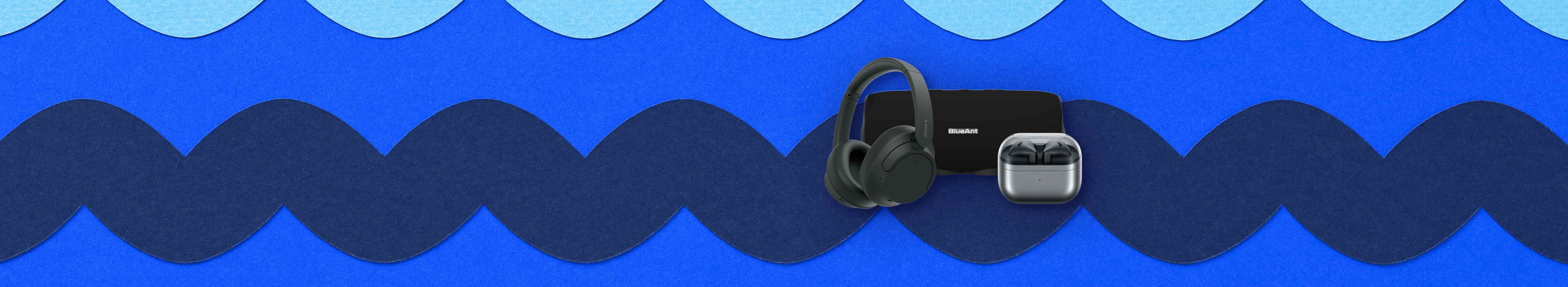 Flat lay of accessories. Left to right: black Sony wireless headphones, black BlueAnt portable speaker in background, and black Samsung Galaxy Buds3 in silver charging case.