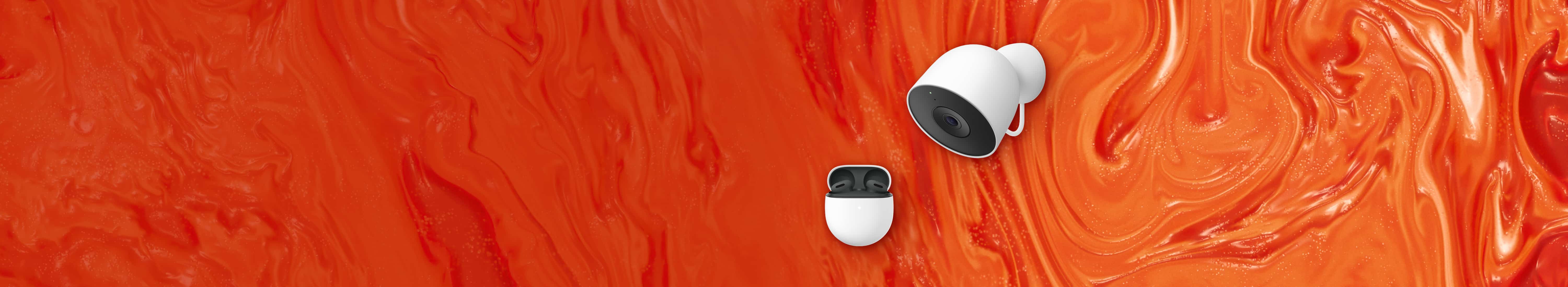 Front view of Google accessories sitting side by side. Black Google Pixel Buds 2a nestled in white charging case to left; white Google Nest Cam with black lens to the right