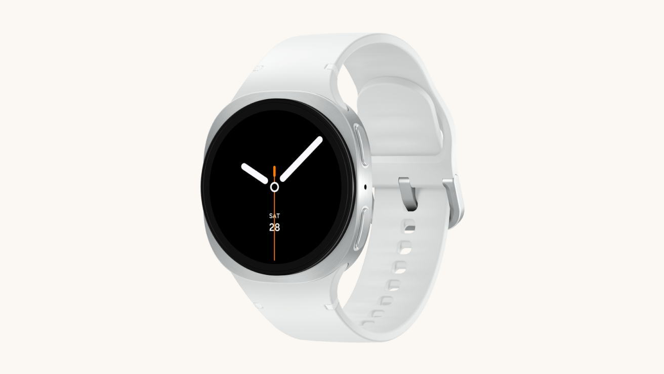 Samsung Galaxy Watch8 with a silver case and white band, featuring a round black display with minimalist white and orange watch hands.