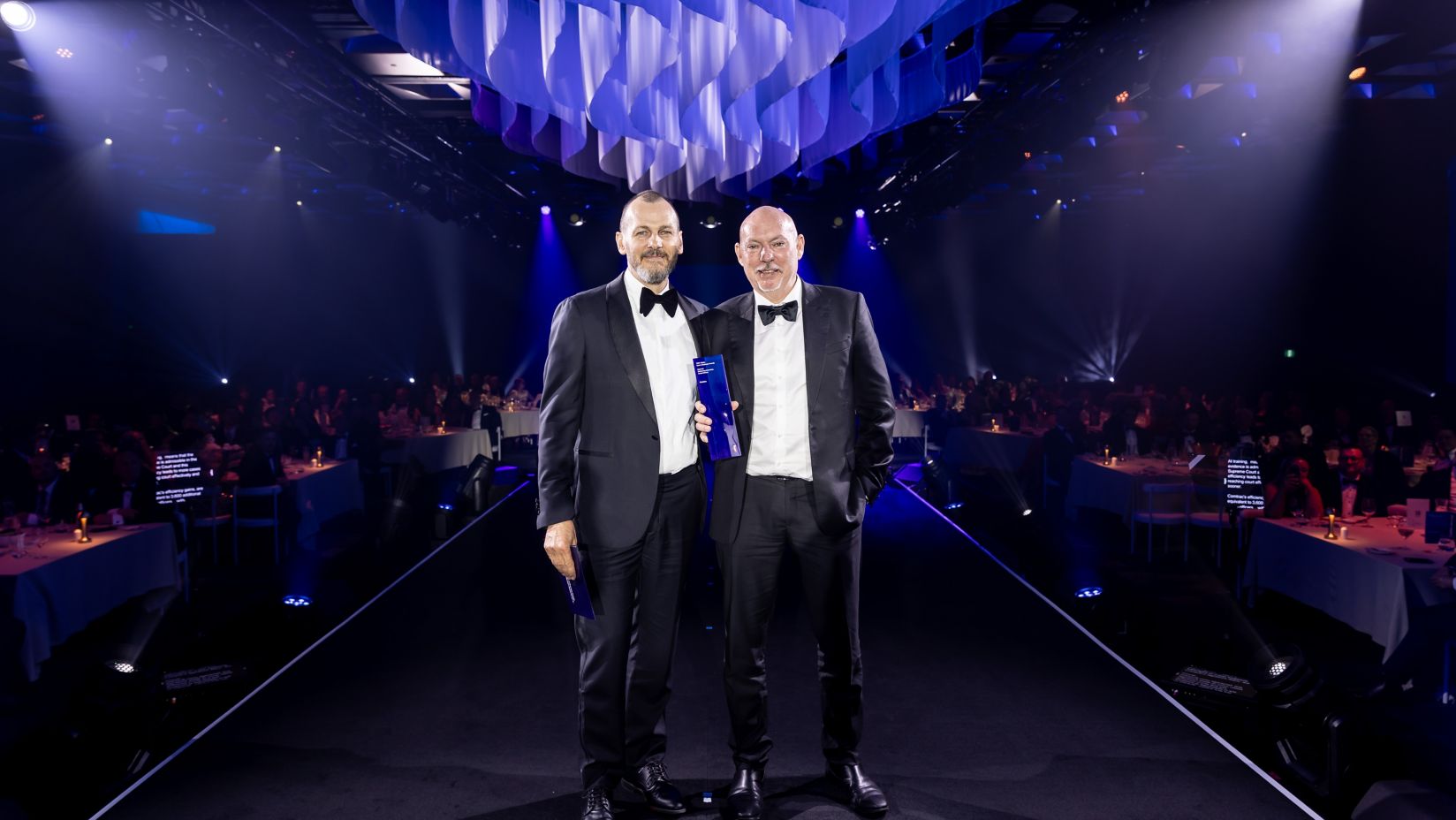 Craig and Jason are onstage smiling with their award.