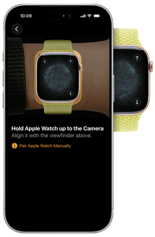 An iPhone showing an Apple Watch pairing screen, with an Apple Watch behind it. The text on the iPhone screen reads Hold Apple Watch up to the Camera. Align it with the viewfinder above. There is a link that reads Pair Apple Watch Manually.